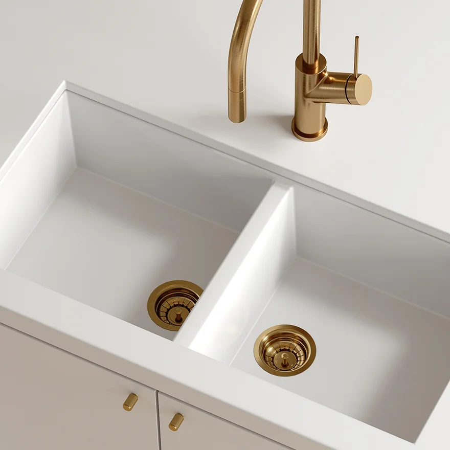 oliveri brushed gold basket wastes installed in a white double bowl kitchen sink Oliveri brushed gold basket wastes installed in a white double-bowl kitchen sink