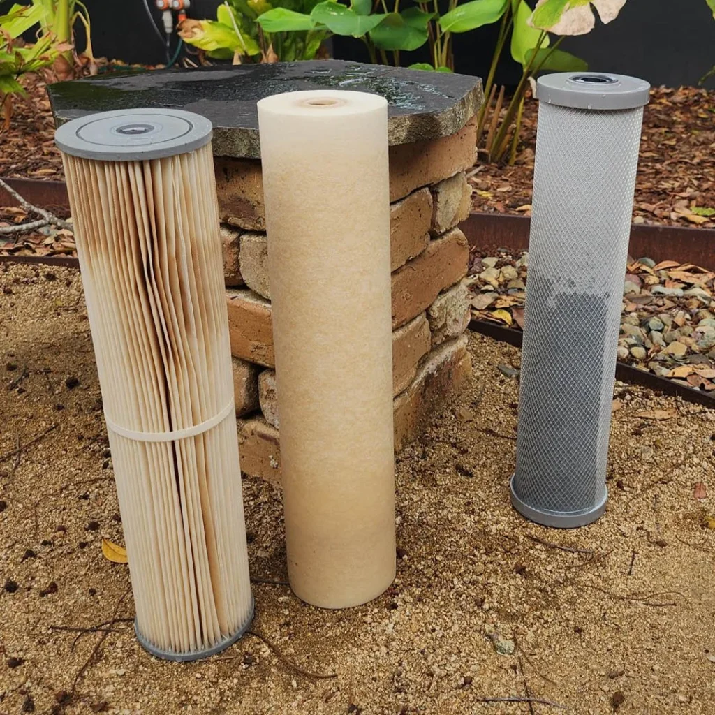 Used sediment filter cartridges beside a new cartridge